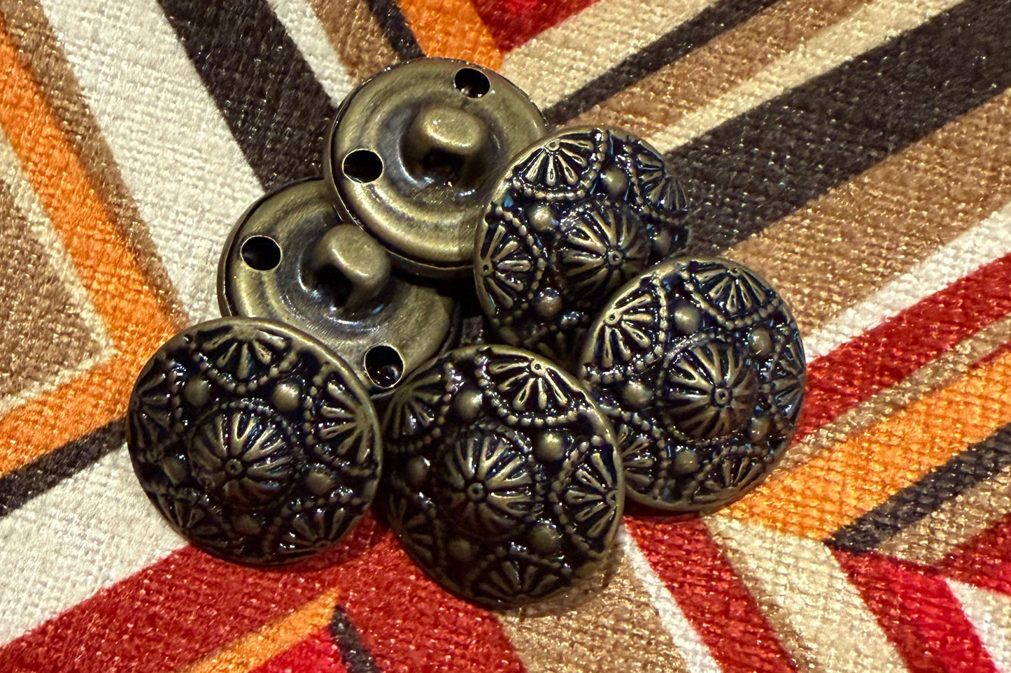 Decorative metal buttons
on a patterned fabric background