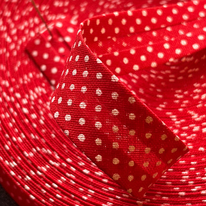 Close-up of red polka dot cotton bias tape showing the folded edges