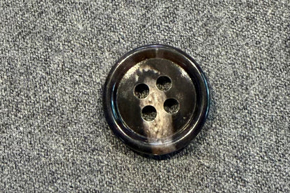 Brown and tan button on a textured gray surface