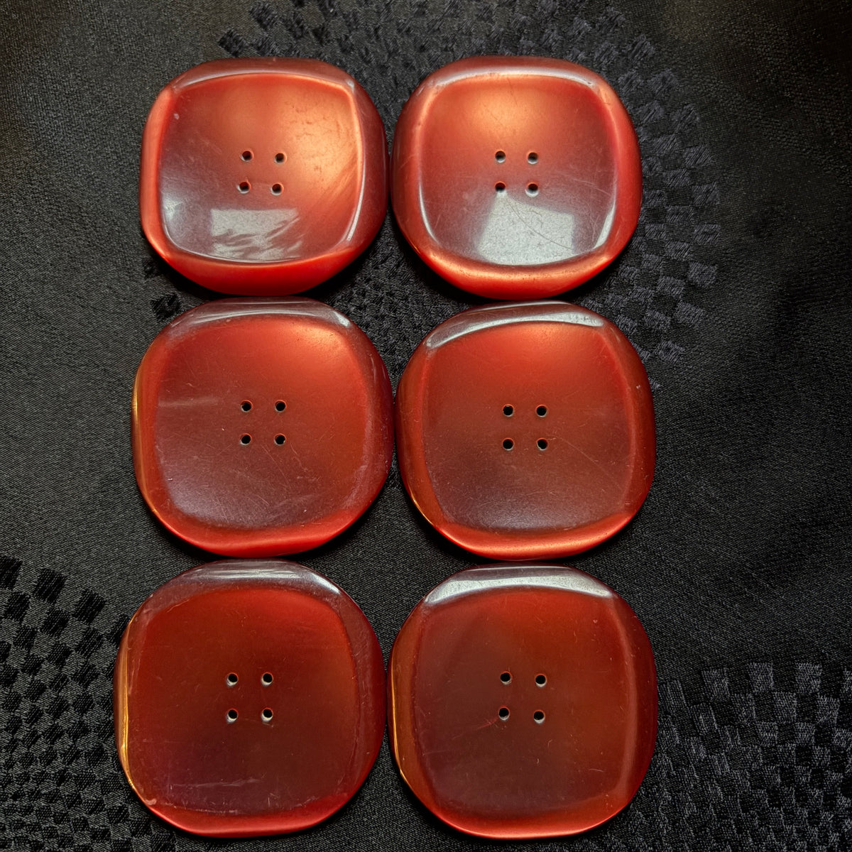 Set of six square red glass statement buttons laid out in two rows