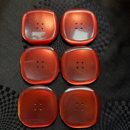 Set of six square red glass statement buttons laid out in two rows