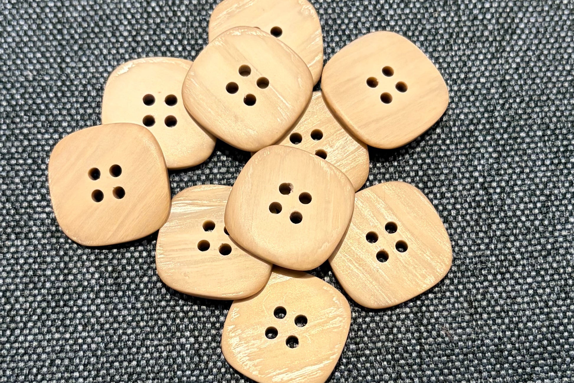 Tan buttons on a gray fabric background