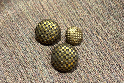 Three textured buttons on a textured fabric surface