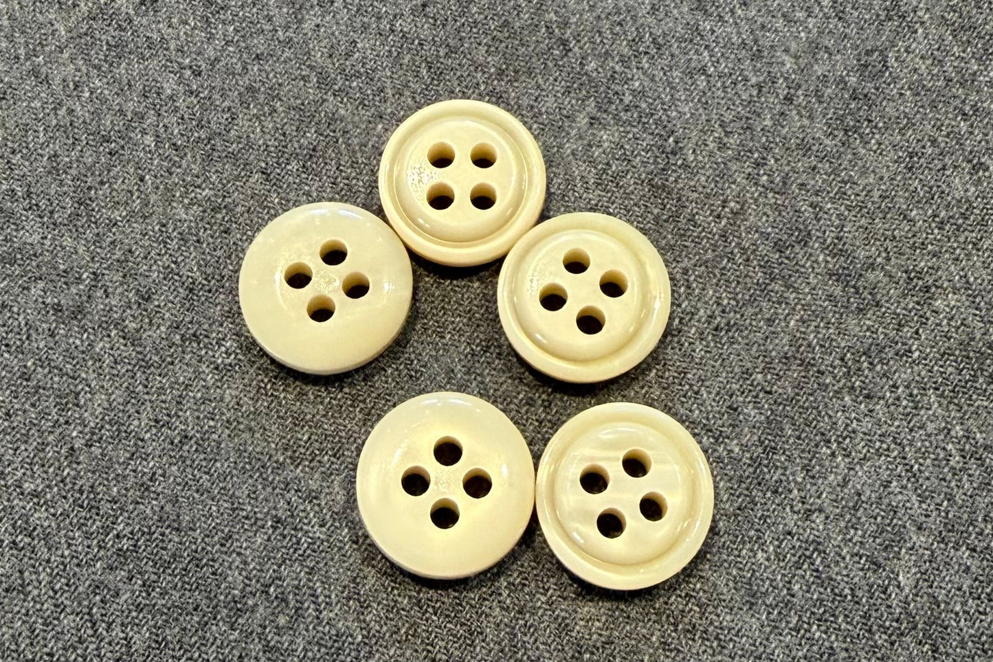 Five white buttons on a textured gray surface