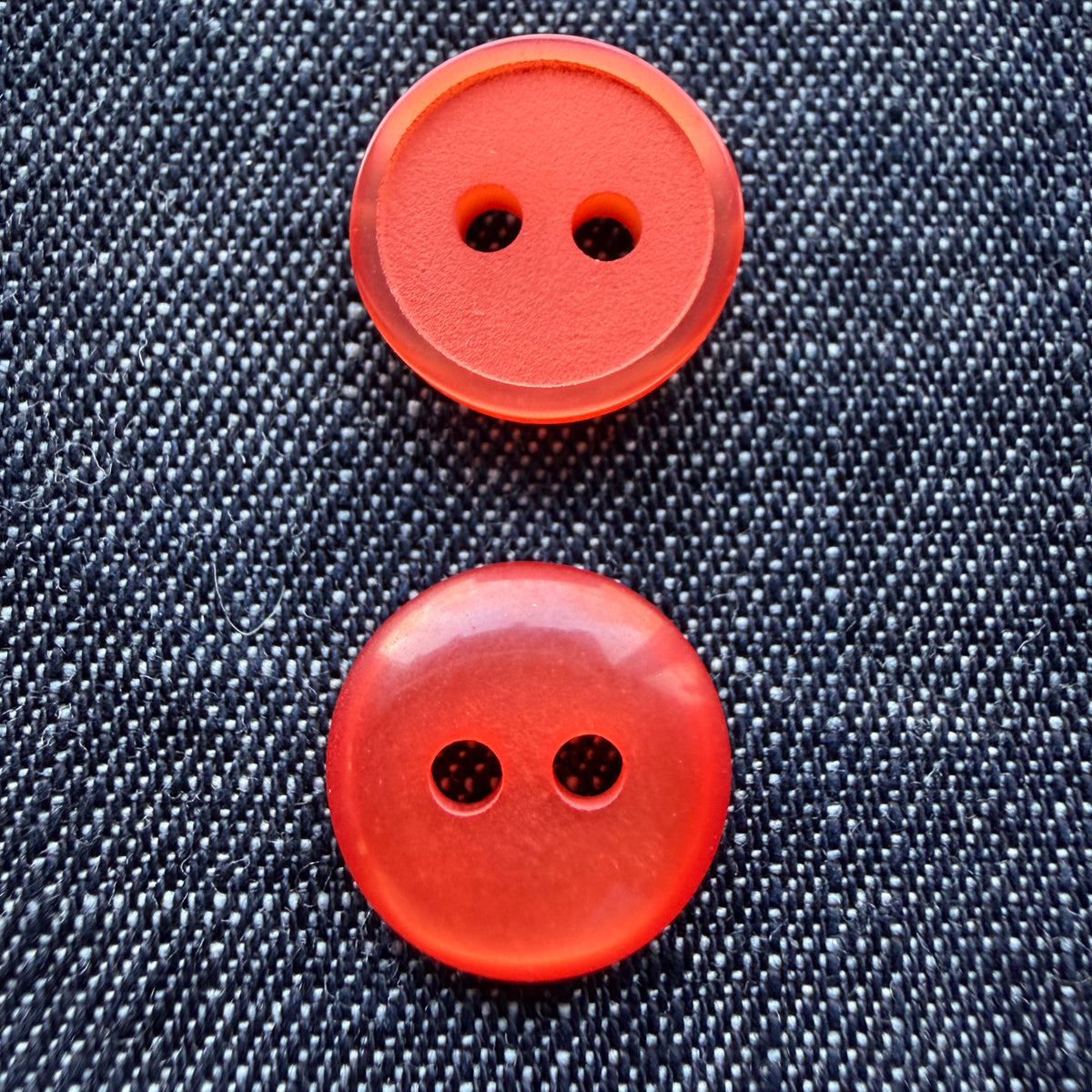 Orange plastic shirt buttons, matte side and glossy side