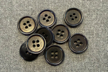 Group of black buttons on grey fabric