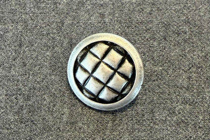 Bouton métallique à texture matelassée
