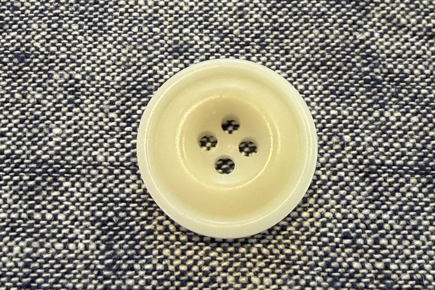 White button on a textured gray fabric background
