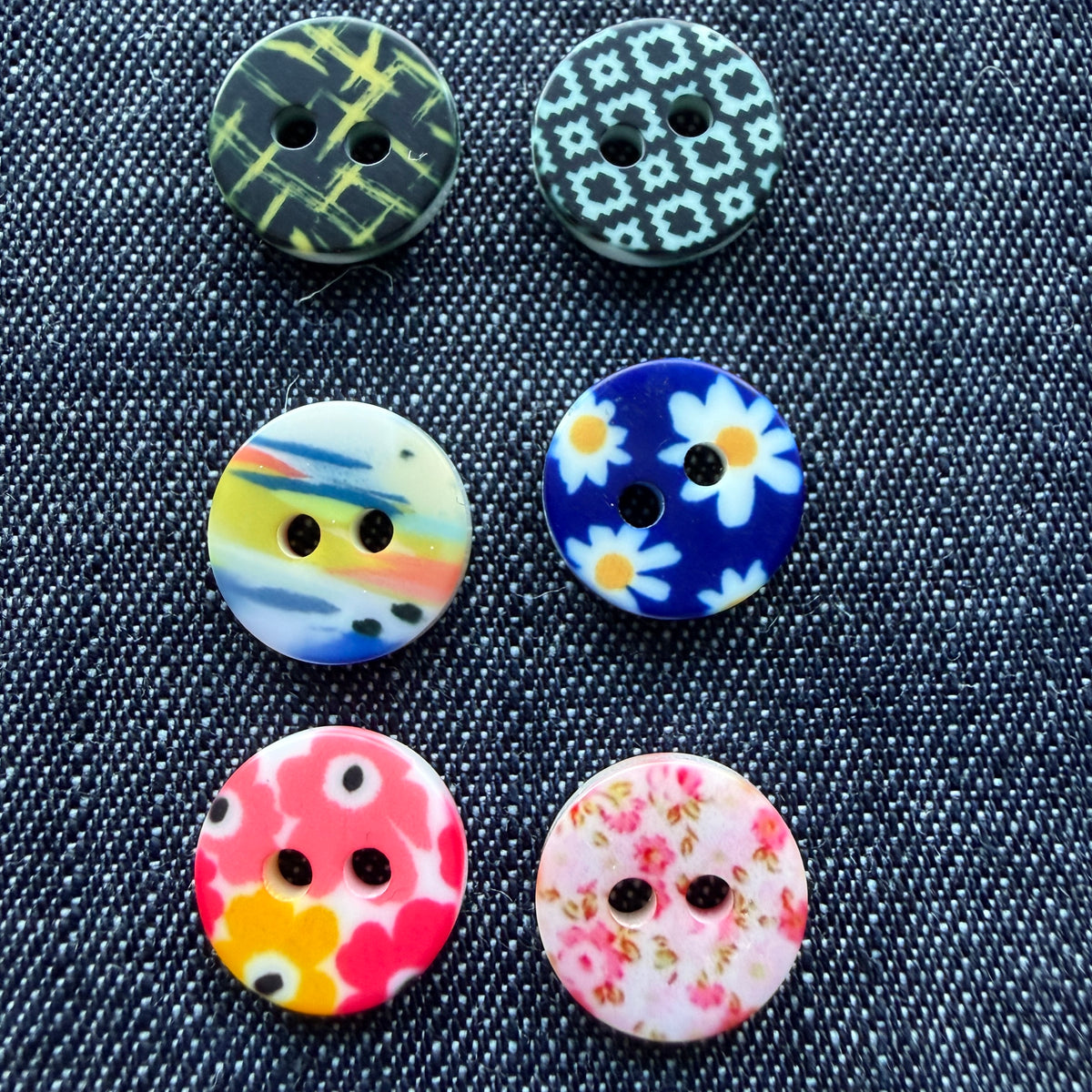 Whimsical patterned plastic shirt buttons in six prints on denim