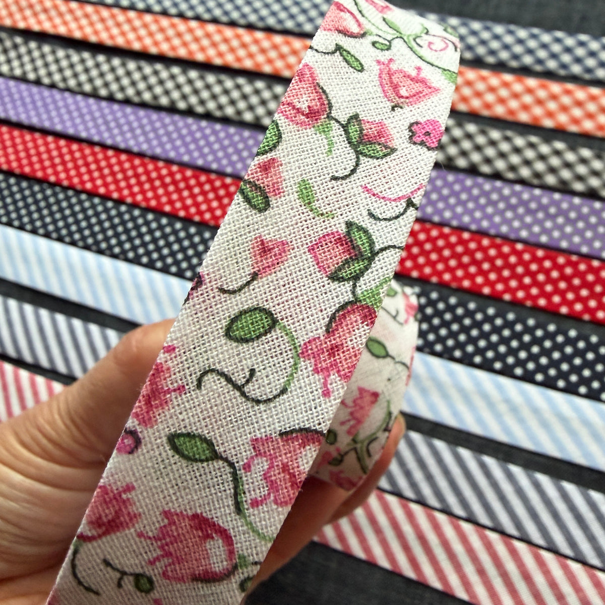Pink floral cotton bias tape held up against the other patterns