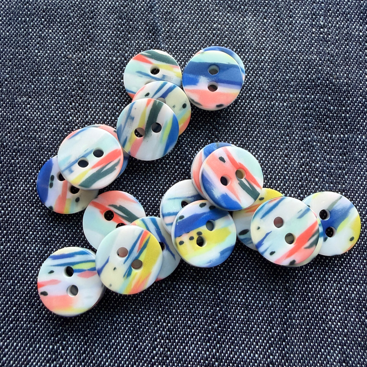 Whimsical patterned plastic shirt buttons in six prints on denim