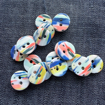 Whimsical patterned plastic shirt buttons in six prints on denim