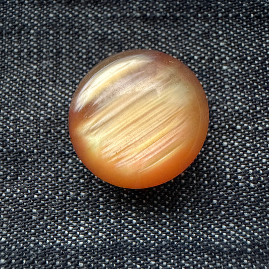Small rose-gold domed casein shank button with peach and gold streaks.