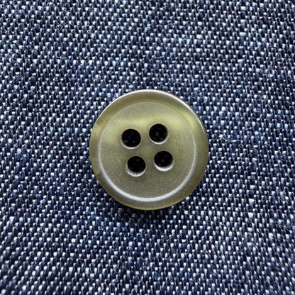 Glossy olive four-hole plastic shirt buttons on denim