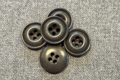 Five grey buttons on a textured gray surface