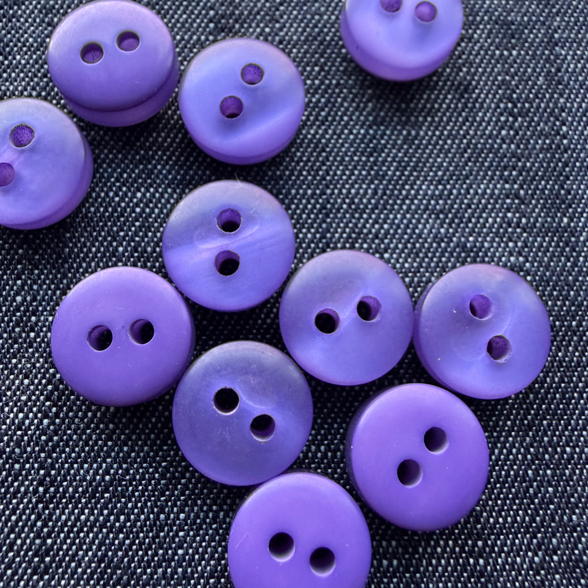 Purple plastic tablet shirt buttons on denim