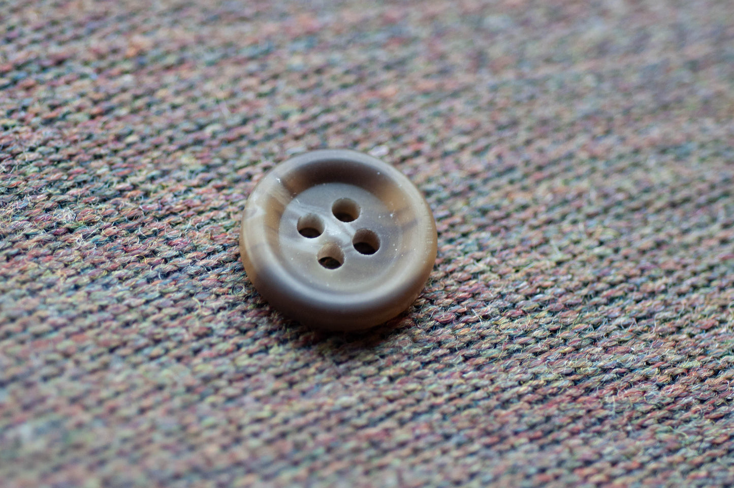 Brown button on a textured fabric background