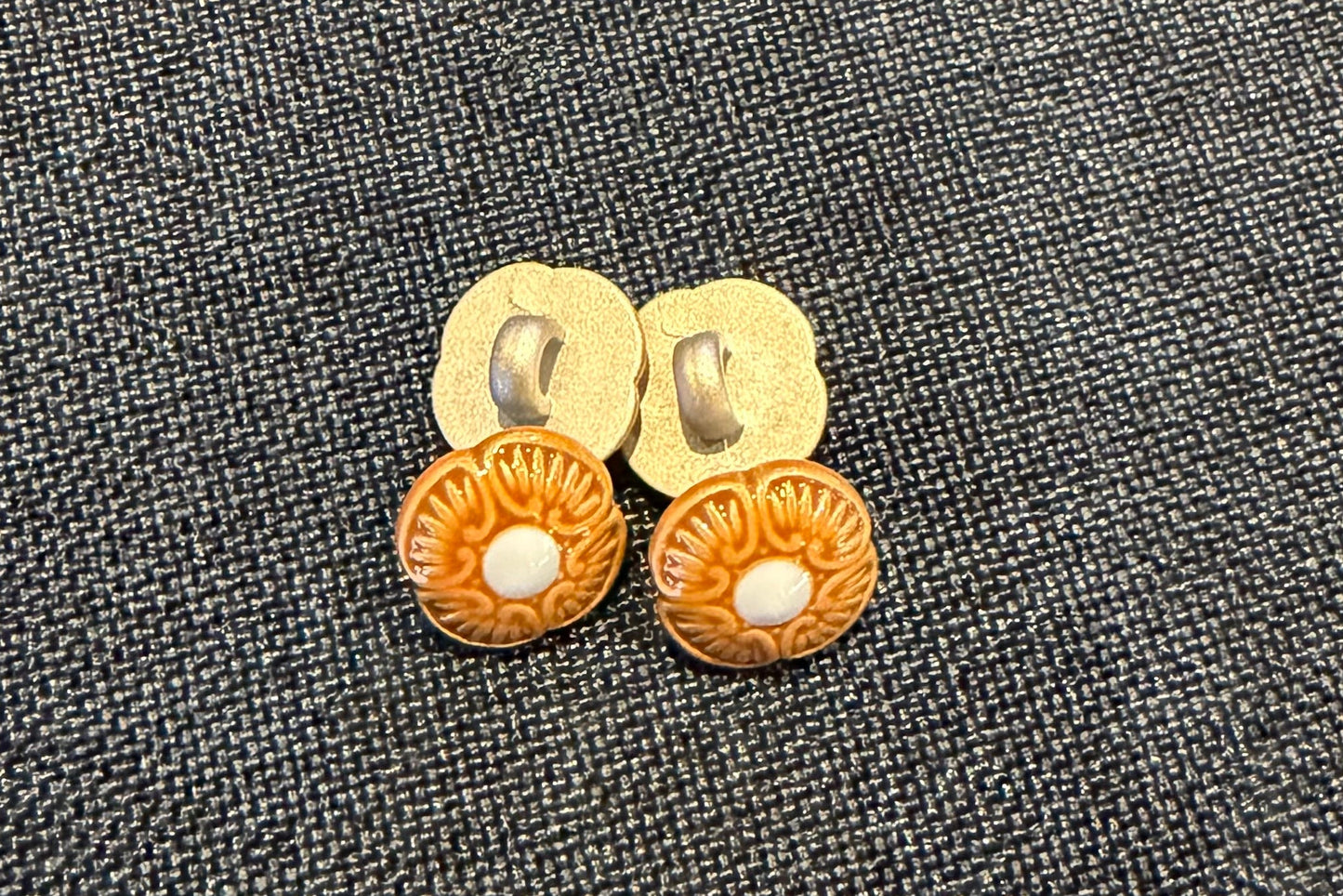 Four floral brown and blue buttons on a blue fabric