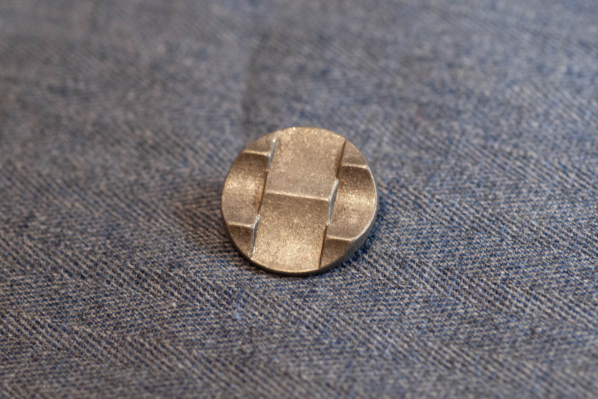 Silver button on a textured gray fabric background